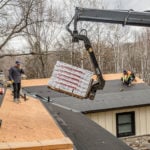 pallets of shingles being lifted by crane