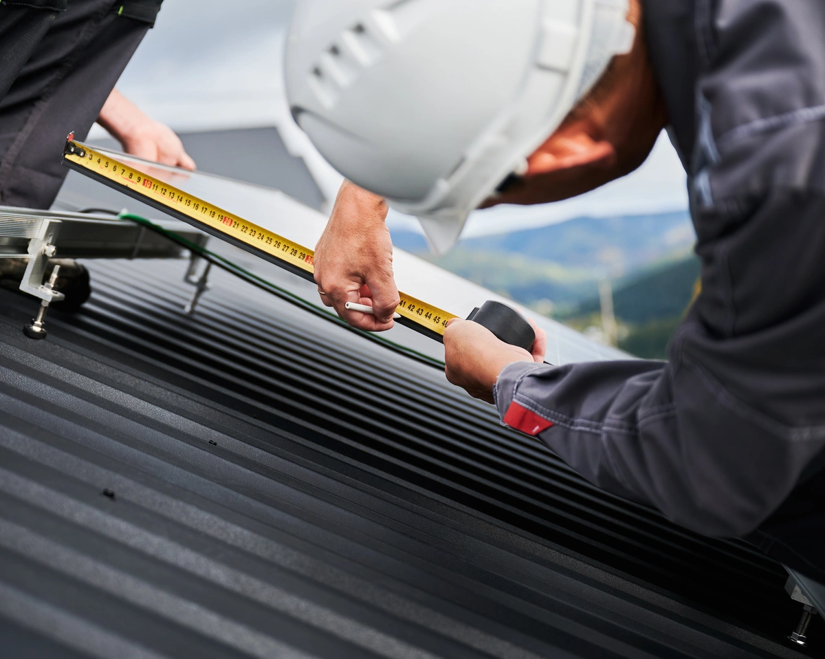 worker measuring the metal roof