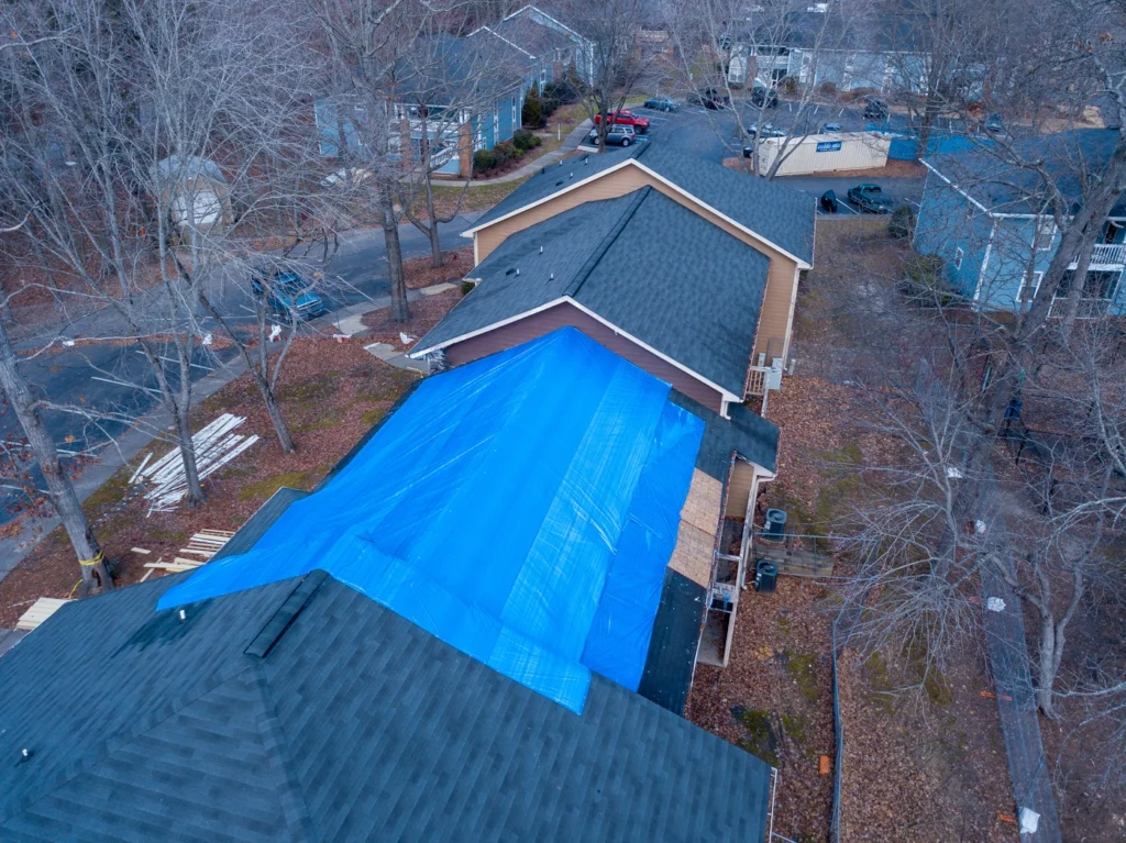 aerial view of shingle roof with emergency roof tarp installation before repairs can be made
