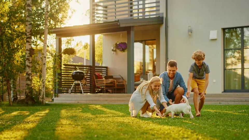 Family and dog with their house in Hudson