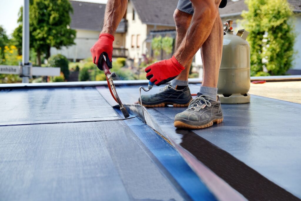 Flat roof installation with propane blowtorch 