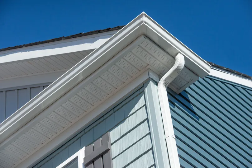 New white gutters on a blue home