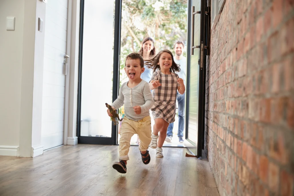 happy children and parents enter home in hugo mn