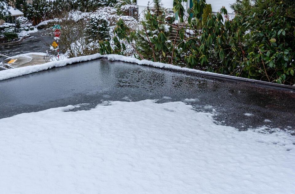 how to prevent ice buildup on a flat roof-close up of ice and snow on a residential flat roof