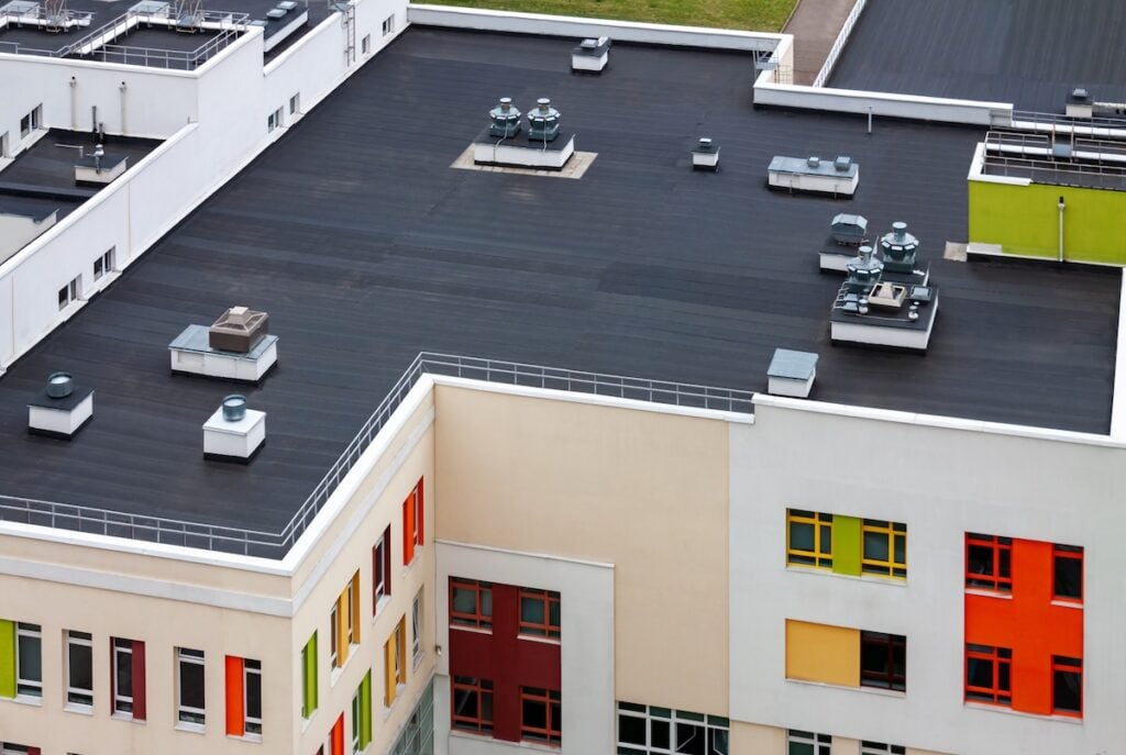 Top view of a flat roof with black roofing material EPDM. Condo Roof Replacement cost