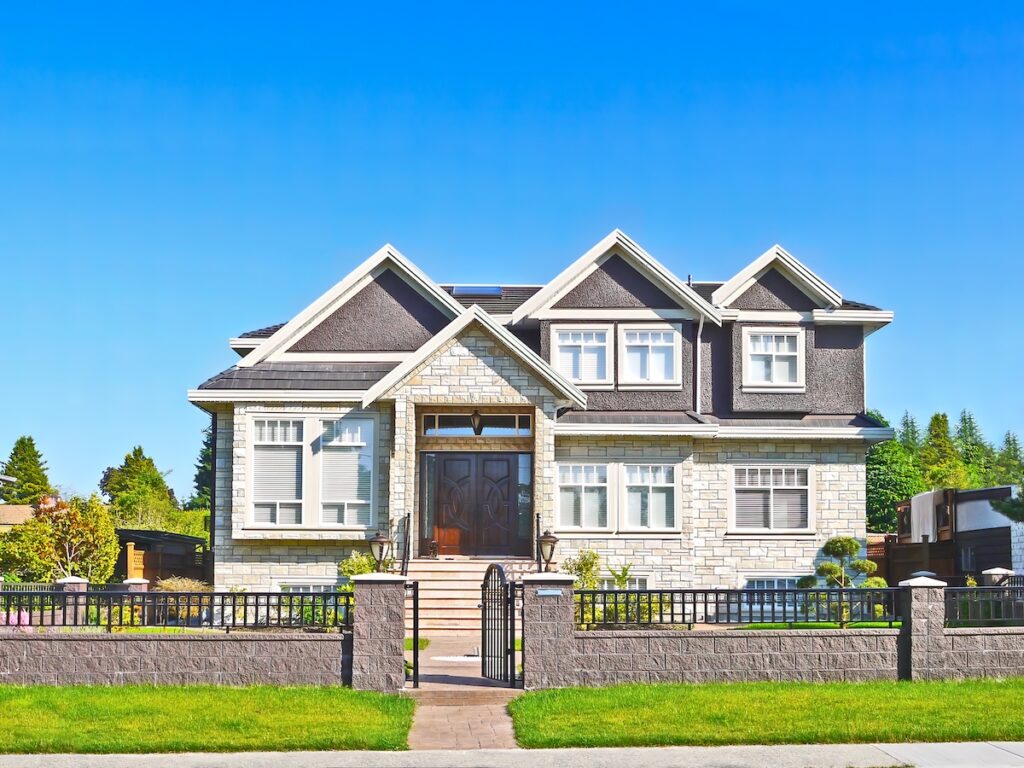 Nice and neat residential house with concrete pathway in the front on bright sunny day